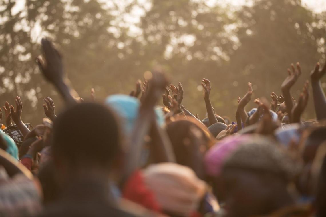 People in crowd with hands raised