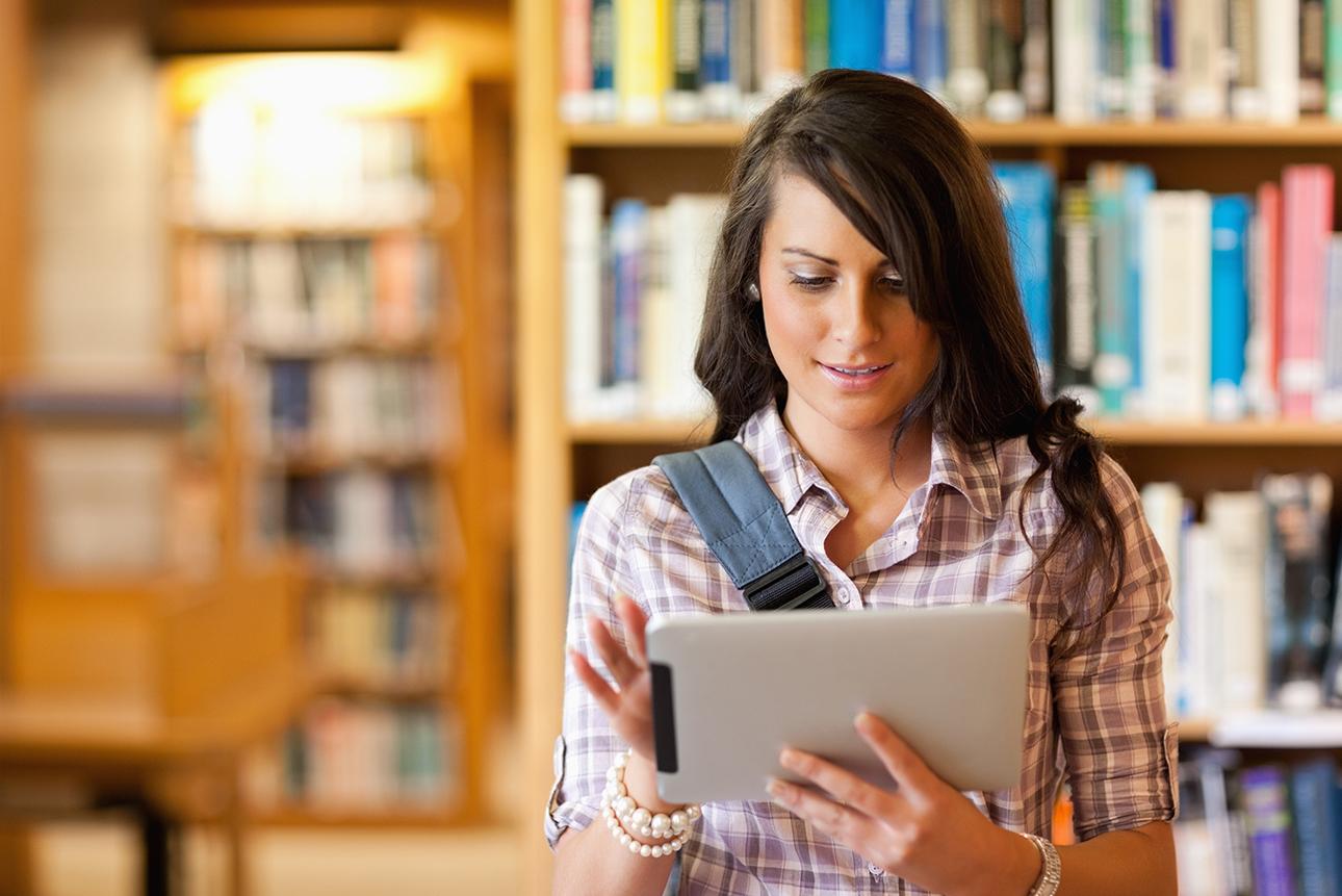 Female student in library working on tablet