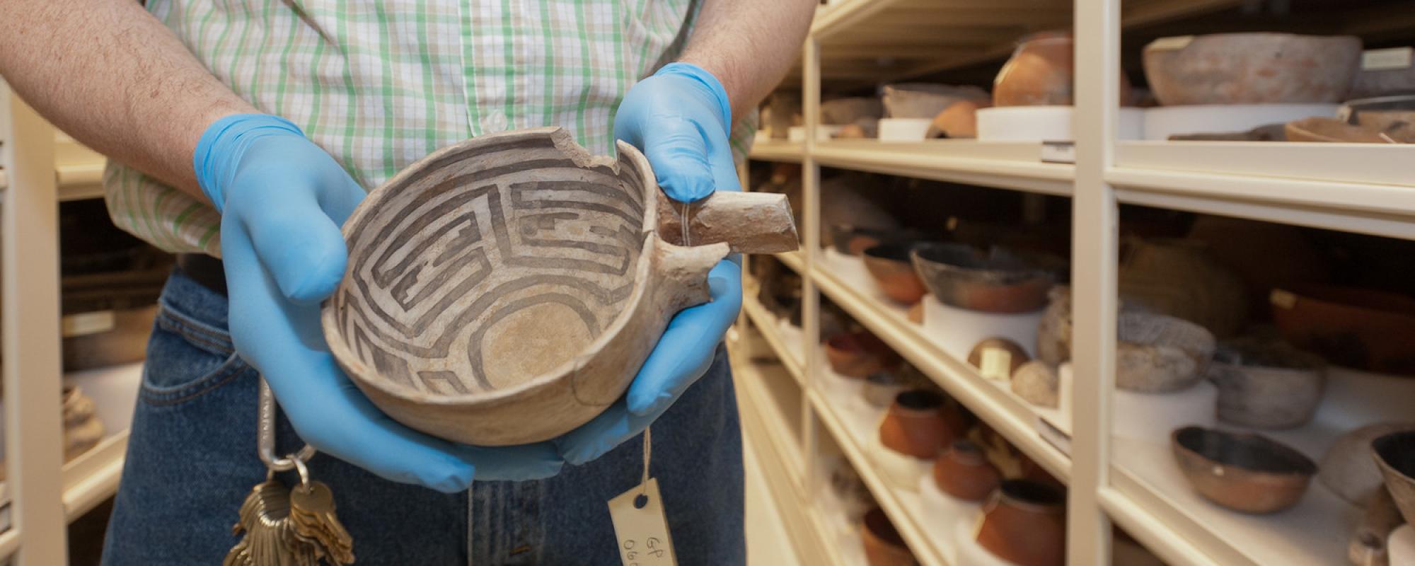 Person holding artificat in museum archive