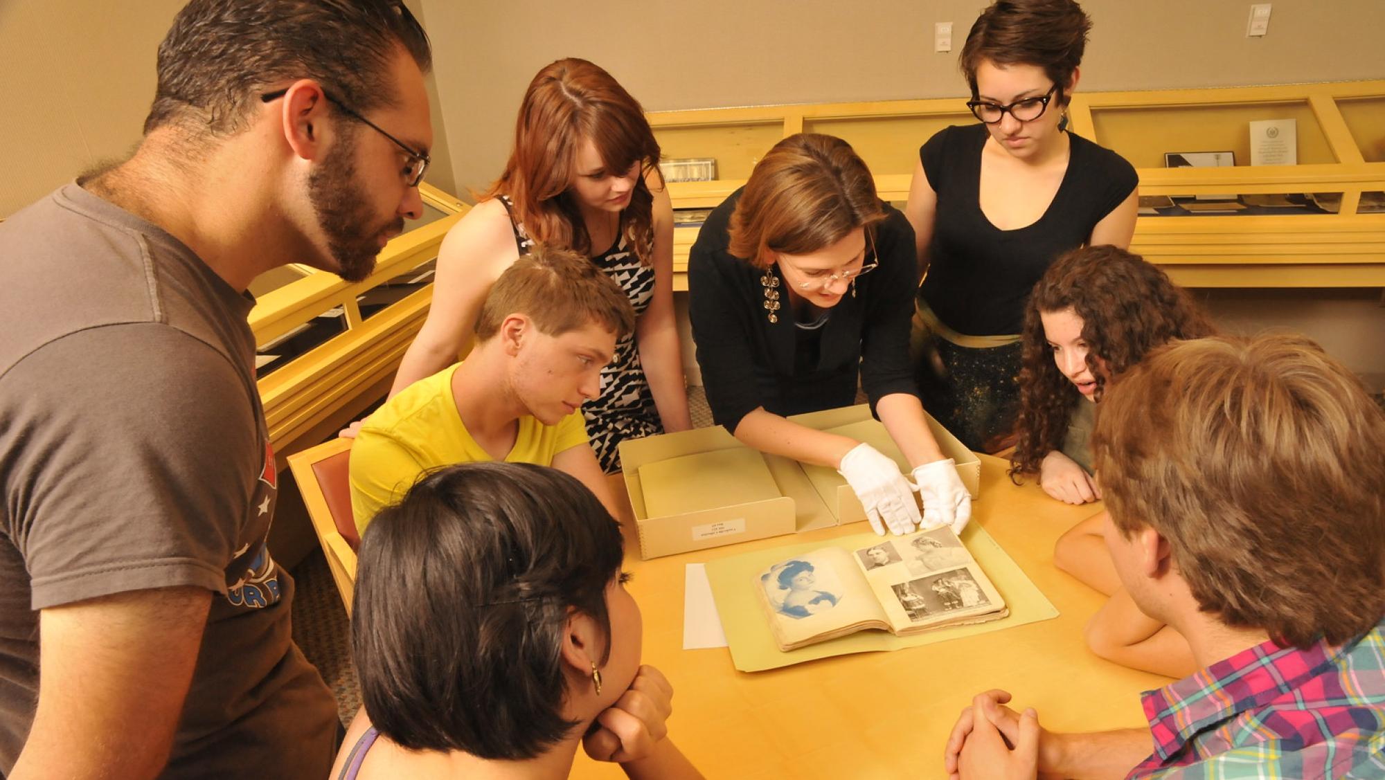 A group of students and instructor examining an artifact