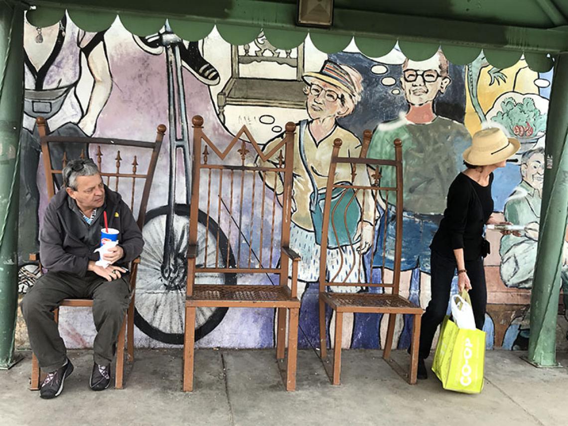 people siting in front on mural
